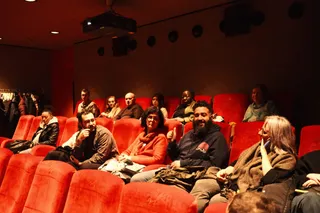 Smiling audience members in red cinema seats at a Locked Out event