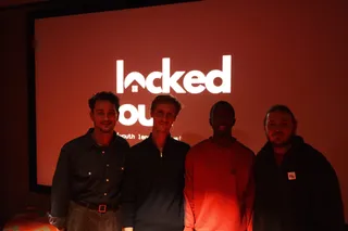 Four people in front of the Locked Out title on the cinema screen