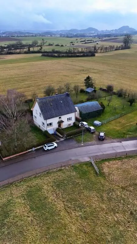 A YWS shared house in Luxembourg: a white detached house among fields, seen from above