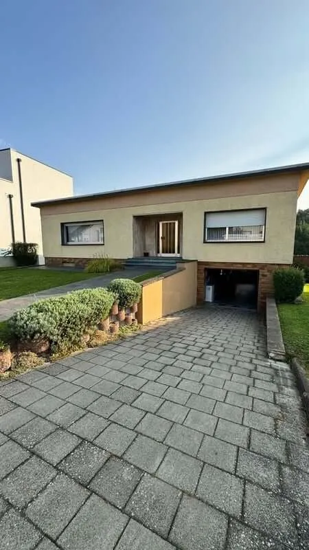 A YWS shared house in Luxembourg: a beige bungalow at the end of a paved driveway